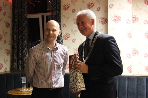 Tim Mourne, Rose Queen treasurer, presents Martin Thomas with Christmas gift