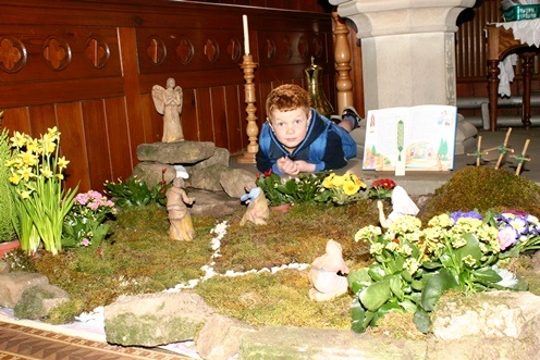 Easter is more than just Easter eggs:  a little boy gets a ground level view of the Easter garden in St James' church, Taxal, remembering the crucifixion and the resurrection 